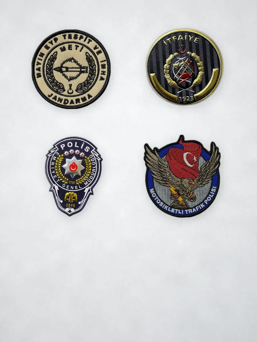 Açık taş zeminde polis ve jandarma patch armaları