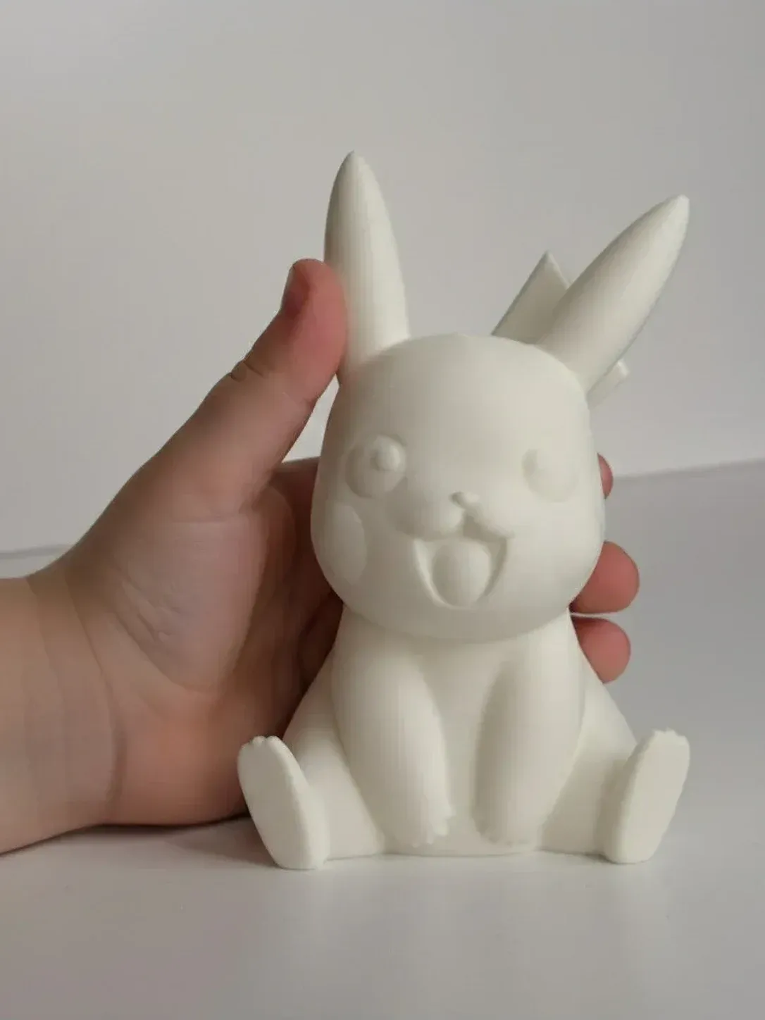 Boyanmamış beyaz 3D baskı figür elde tutuluyor