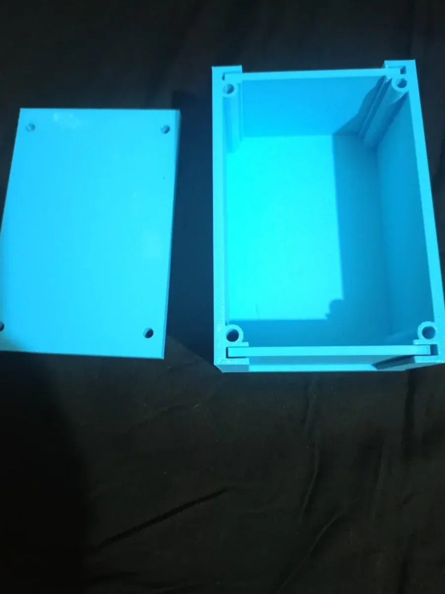 Siyah kumaş üstünde açık mavi 3D baskı proje kutusu ve kapağı