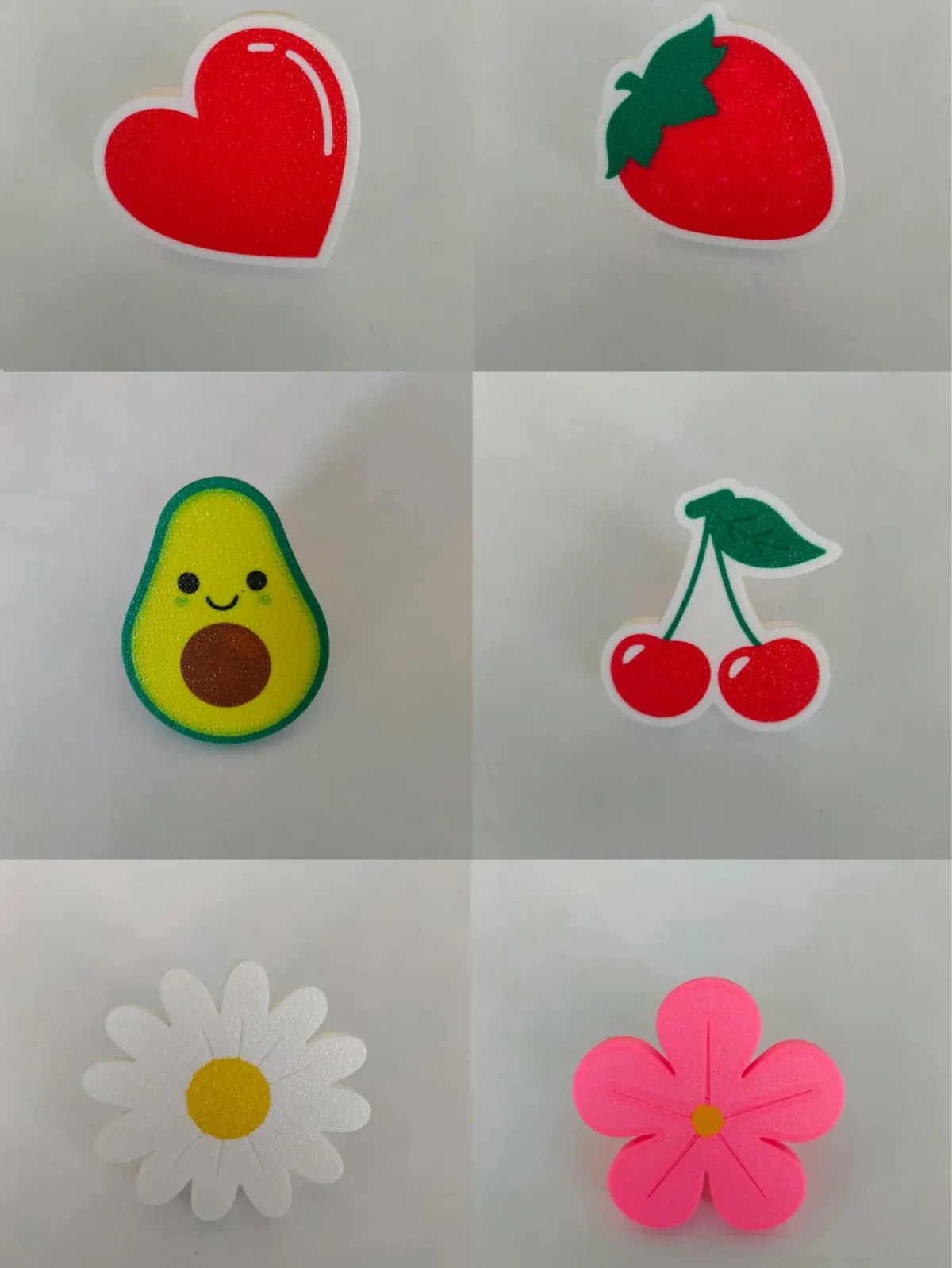 Beyaz dolap kapaklarında kalp, çilek, avokado, kiraz, papatya ve çiçek formlu 3D baskı kulplar