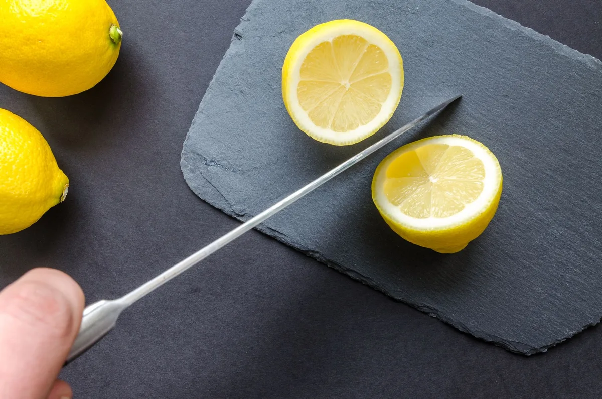 Kesme tahtasında ikiye bölünmüş limonlar